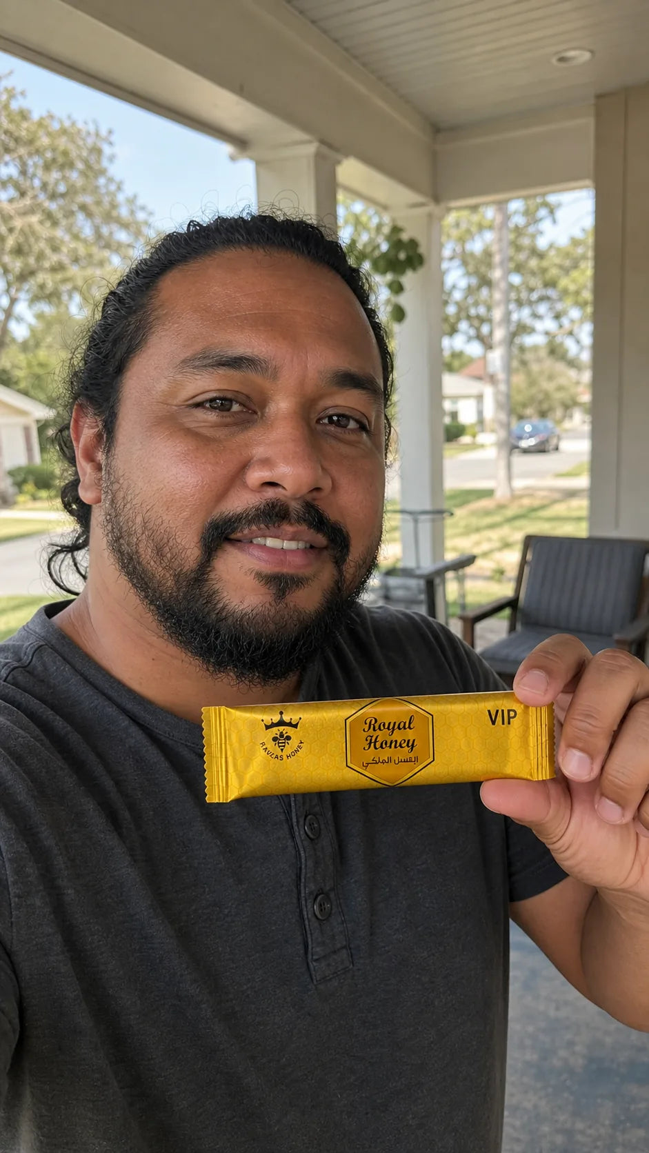 Lifestyle portrait of a man holding a Royal Honey sachet on a front porch